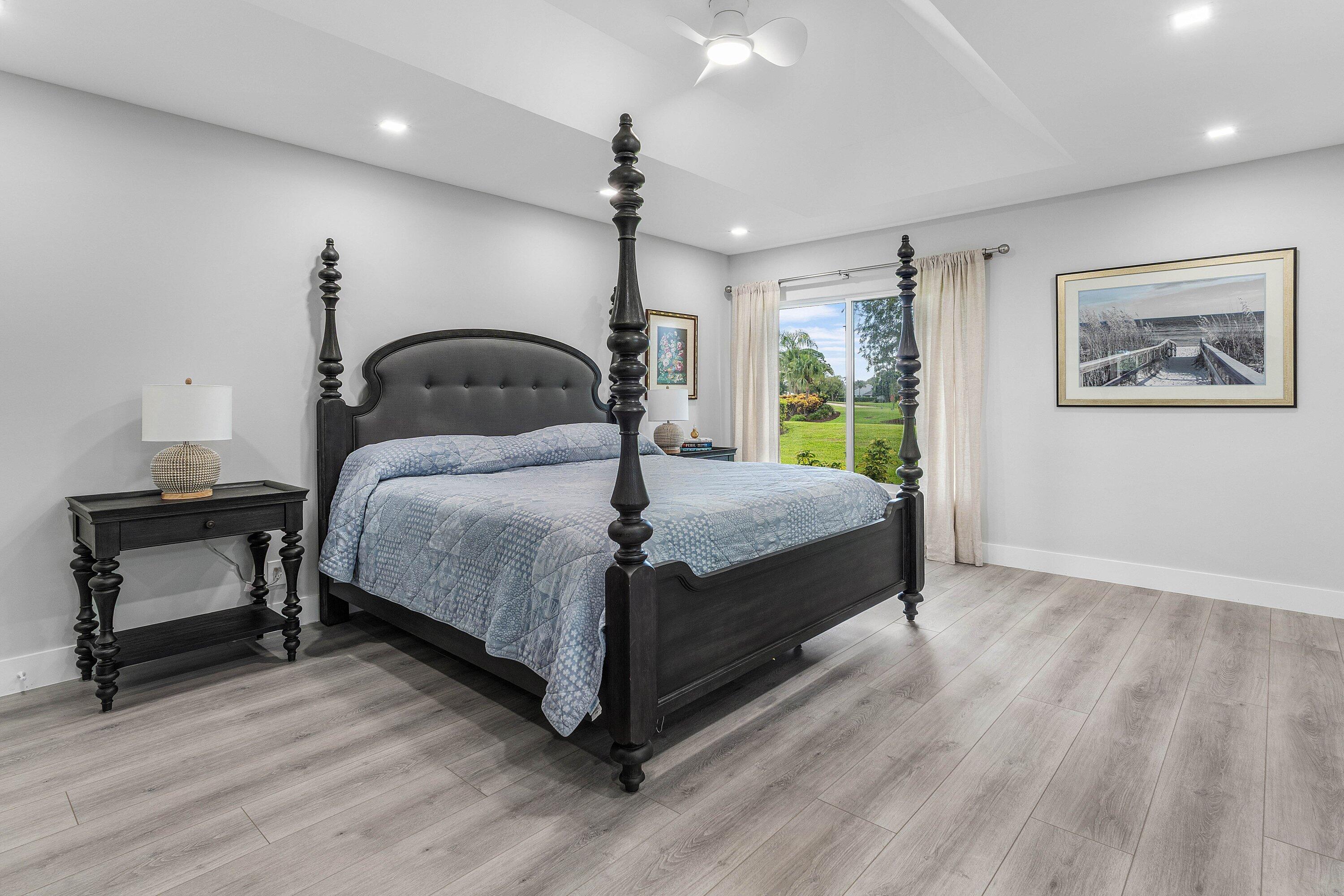 Renovated kitchen at 13320 Touchstone Court, Palm Beach Gardens, with white custom cabinetry, stone counters, glass tile backsplash and stainless appliances